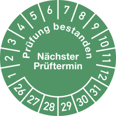 Grüne Prüfplakette mit den Zahlen 1 bis 12 und 26 bis 31, Text Prüfung bestanden und Nächster Prüftermin