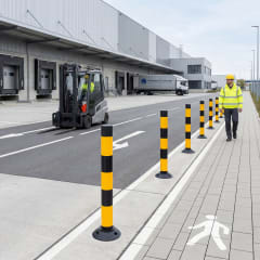 Leitzylinder FLEXPIN und FIXPIN Absperrpfosten und LeitPin in gelb-schwarzen Streifen auf einem Parkplatz mit Gabelstapler und Arbeiter
