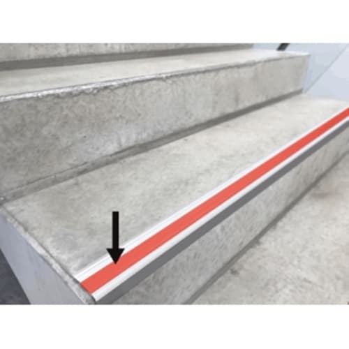 PVC-Einlage für Stufenmarkierungsprofil aus Aluminium auf einer Treppenstufe mit rotem Streifen