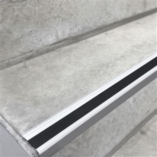 Stufenmarkierungsprofil aus Aluminium mit schwarzem rutschfestem Streifen auf einer Treppenstufe aus Beton