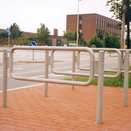Anlehnbügel mit Rundrohrrahmen aus Metall auf gepflastertem Boden an einer Straße