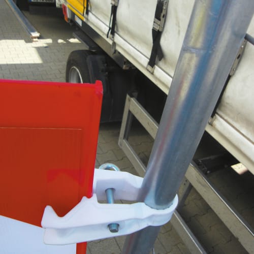 Weiße Verbindungsklemme aus Kunststoff befestigt rotes Verkehrszeichen an Metallrohr