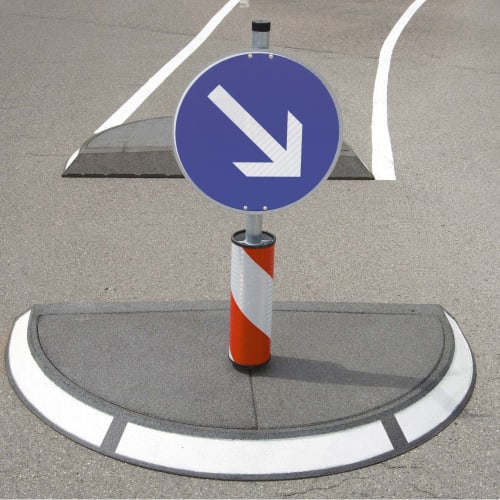 Verkehrsinsel GAMMA mit blauem Verkehrsschild und weißem Pfeil nach rechts unten auf grauem Asphalt