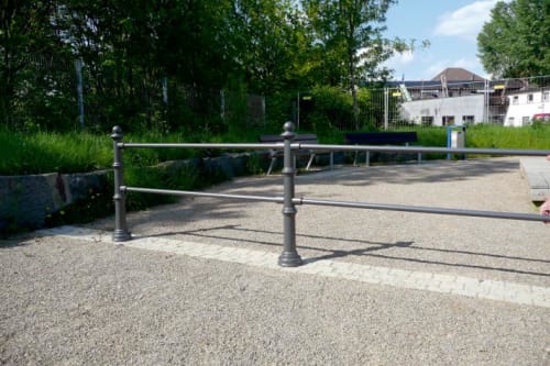 Querholm Schutzgeländer-System mit Aluminium Stilpollern auf einem Kiesweg im Außenbereich