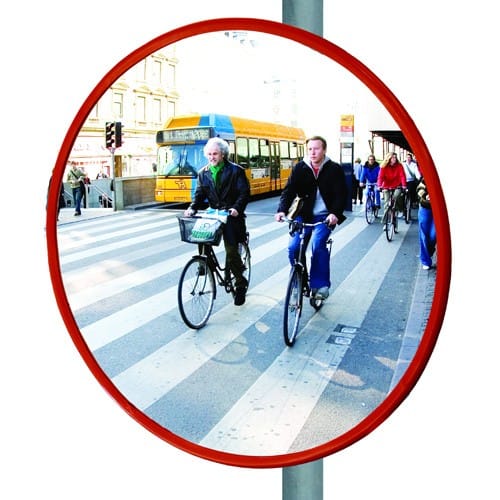 Verkehrsspiegel für Radfahrer TRIXI mit rotem Rahmen zeigt zwei Radfahrer auf einem Zebrastreifen vor einem Bus in der Stadt