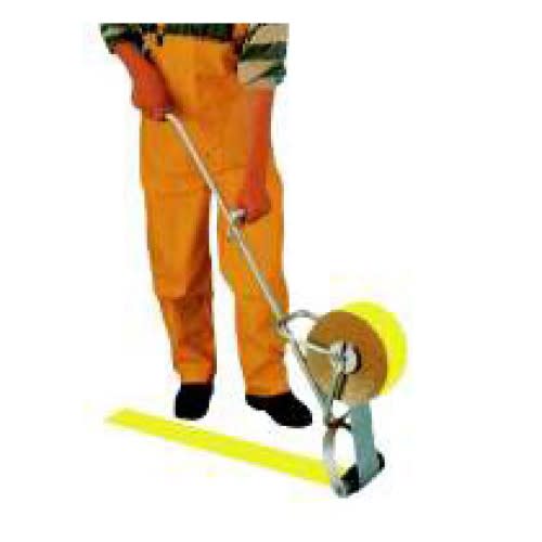 Person mit Andrückrolle für Fahrbahnmarkierungsfolie beim Aufbringen einer gelben Markierungslinie