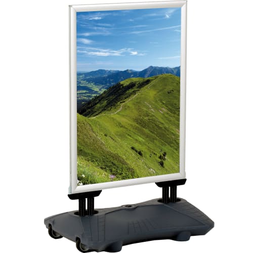 Kundenstopper WindPro mit wetterfestem Rahmen und Bild einer grünen Berglandschaft unter blauem Himmel