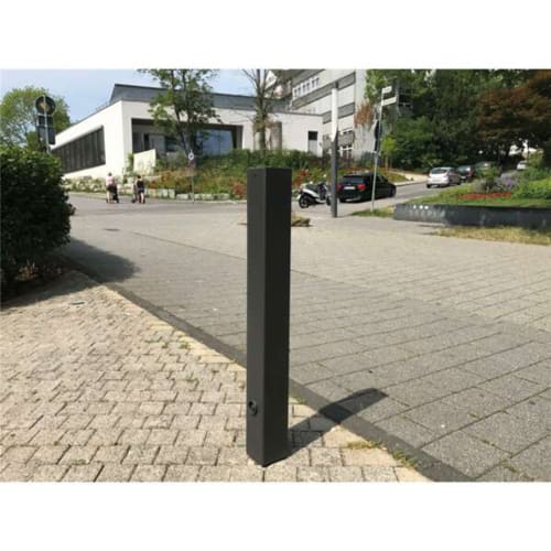 Stilpoller mit Flachkopf viereckig aus Metall auf Gehweg in urbaner Umgebung