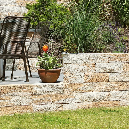 Beton-Mauerstein Massivo Classico Ergänzungsstein in Gartenmauer mit Pflanzen und Stühlen