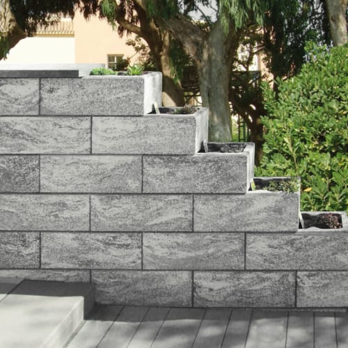 Beton-Mauerstein Recto als gestufte Gartenmauer mit integrierten Pflanzkästen in grauer Farbe