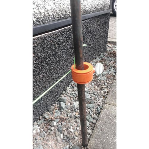 6 Stk. Probst Richtschnurhalter orange an Metallstab mit grüner Richtschnur im Außenbereich