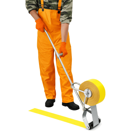 Person in orange Arbeitskleidung verwendet Andrückrolle für Fahrbahnmarkierungsfolie zum Aufbringen einer gelben Markierung
