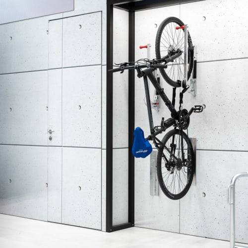 Fahrradaufhängung Bike Lift mit Wandschutz für Hinterrad an moderner Betonwand mit aufgehängtem Fahrrad
