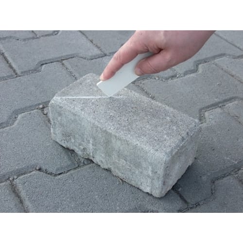 Hand markiert Pflasterstein mit weißem Pflastermarker