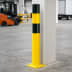 Rammschutzpoller WACHTWERK X aus Stahl in gelb und schwarz mit Stärke L Ø 159 mm in einer Lagerhalle neben einer Säule