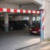 Höhenbegrenzer WACHTWERK X® mit rot-weißen Markierungen an der Einfahrt einer Tiefgarage mit geparkten Autos