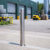 Edelstahlpoller BERLIN Absperrpfosten aus Edelstahl mit geschweißter Kappe auf gepflastertem Boden vor Lagerhalle