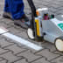 Markierungs-Set NEW PERFEKT STRIPER mit 12 Dosen Markierungsspray Traffic EXTRA beim Auftragen einer weißen Markierung auf Pflastersteine
