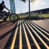 Temposchwelle TOPSTOP für Fahrräder auf einem Radweg mit Fahrradfahrer im Hintergrund