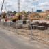 Absperrgitter Typ C auf einer Baustelle zur Absicherung des Bereichs mit Bauarbeitern und Baumaschinen im Hintergrund
