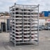Lager- und Transportgestell aus Metall mit mehreren weißen und roten TL Klappbaken Typ 750 gestapelt auf einer Baustelle