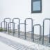 Fahrradständer Kappa® aus Metall, mehrere Fahrradhalterungen nebeneinander auf gepflastertem Boden vor weißer Wand mit Fenster