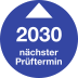Prüfplakette mit blauem Hintergrund und weißem Pfeil, zeigt nächsten Prüftermin 2030
