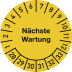 Gelbe Prüfplakette mit der Aufschrift Nächste Wartung und Zahlen von 1 bis 33 zur Kennzeichnung des nächsten Wartungstermins