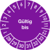 Prüfplakette mit der Aufschrift 'Gültig bis' und Zahlen von 1 bis 12 sowie 28 bis 33 in lila