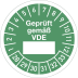 Grüne Prüfplakette mit der Aufschrift Geprüft gemäß VDE und Zahlenring von 1 bis 33