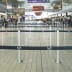 Gurtabsperrpfosten Beltrac Classic Twist mit drehbarem Kopf in einem Flughafen mit schwarzen Absperrbändern