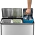 Tret-Mülleimer EcoCasa Recycler EKO mit drei Fächern und 3x 15 Liter Fassungsvermögen, Edelstahl mit geöffnetem Deckel und Hand hält blauen Behälter mit Plastikflaschen