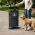 Stand-Abfallbehälter mit integriertem Beutelspender und 70 Liter Fassungsvermögen im Park mit Person und Hund
