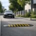 Fahrbahnschwelle SAFE RIDE mit gelben Markierungen auf Straße vor schwarzem Auto