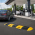 Richtstange für Fahrbahnschwelle TOPSTOP aus Kautschuk in Gelb und Schwarz an einer Tankstelle mit Autos