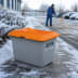 Streugutbehälter 200 Liter aus GFK mit orangefarbenem Deckel ohne Entnahmeöffnung von CEMO im Winter auf schneebedecktem Gehweg
