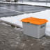 Streugutbehälter 200 Liter aus GFK mit orangefarbenem Deckel ohne Entnahmeöffnung auf schneebedecktem Parkplatz